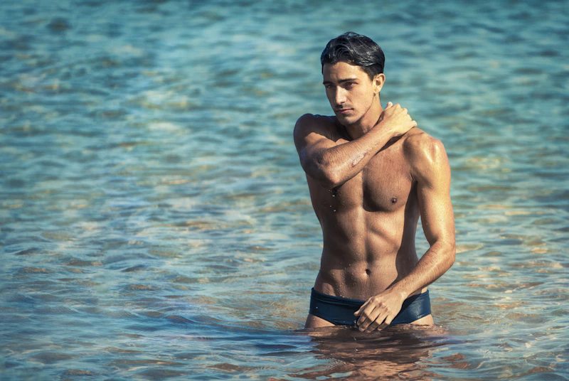 homme torse nu en short noir sur l'eau en journée