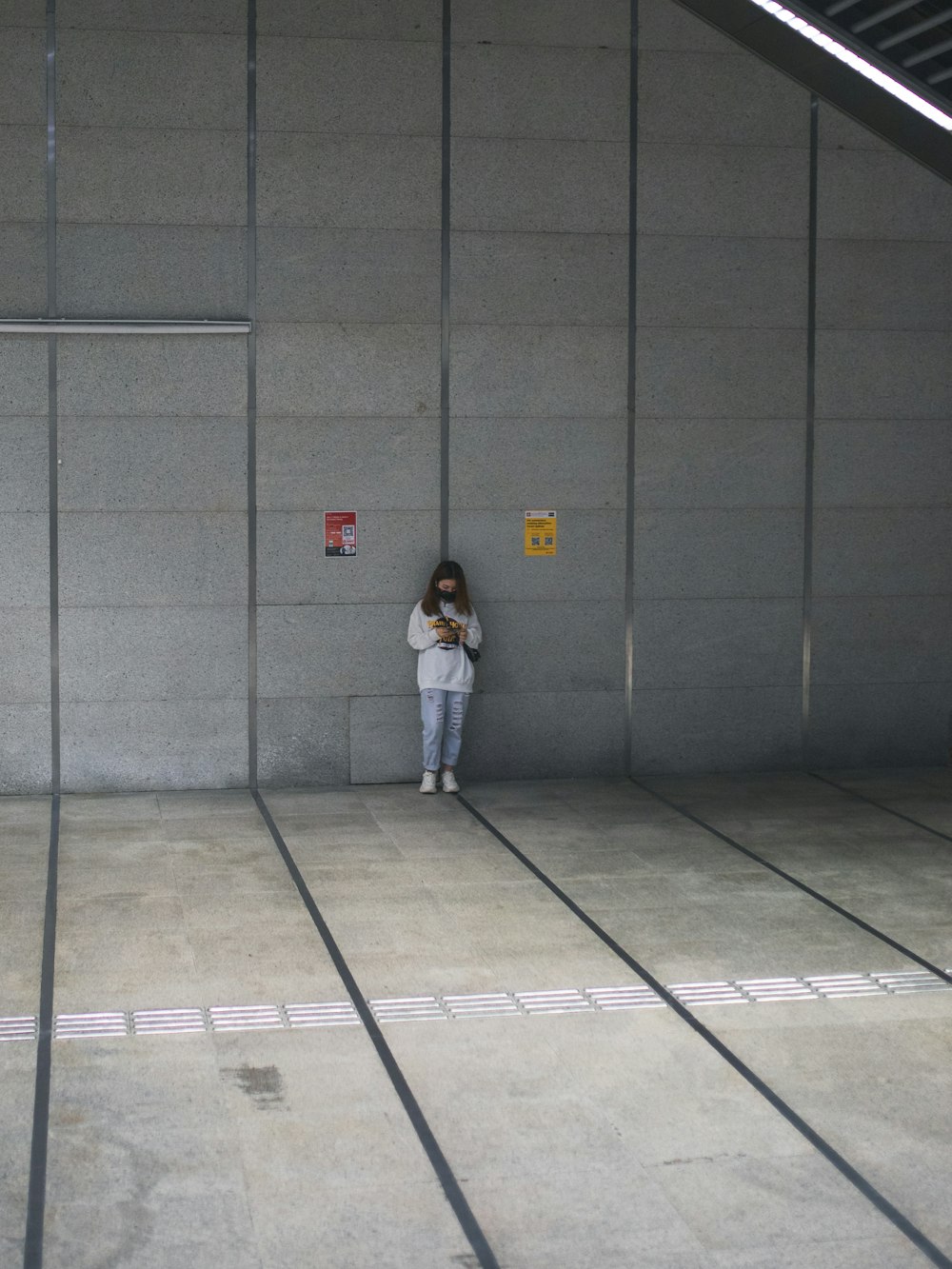 man in white shirt standing on gray concrete floor