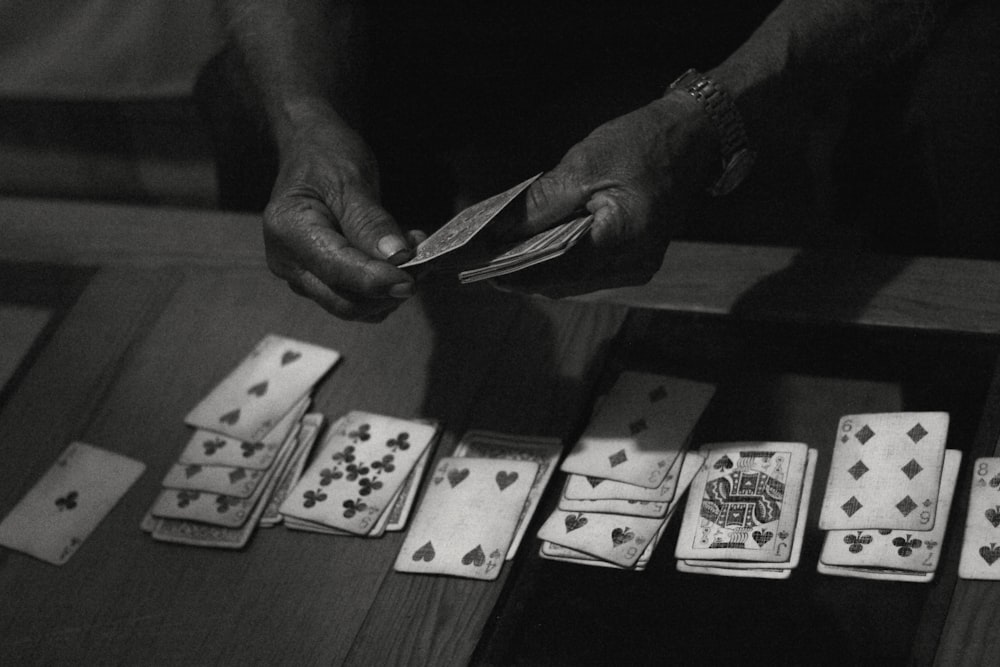 person holding 10 and 10 playing cards