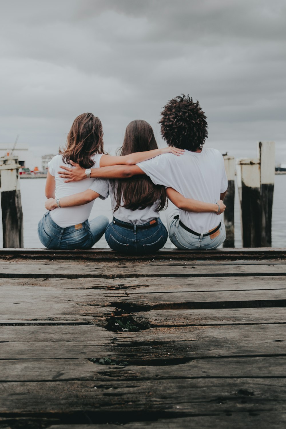 couple sitting on wooden dock during daytime