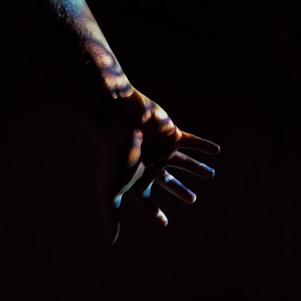 persons hand with black background