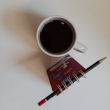 Compact calculator resting beside a cup of coffee and a notepad.