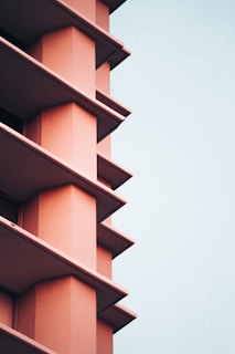 Wide shot capturing the salmon-pink split unit and its distinct, vivid air current against the neutral wall.