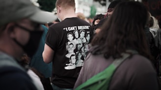 man in black crew neck t-shirt standing beside man in green jacket