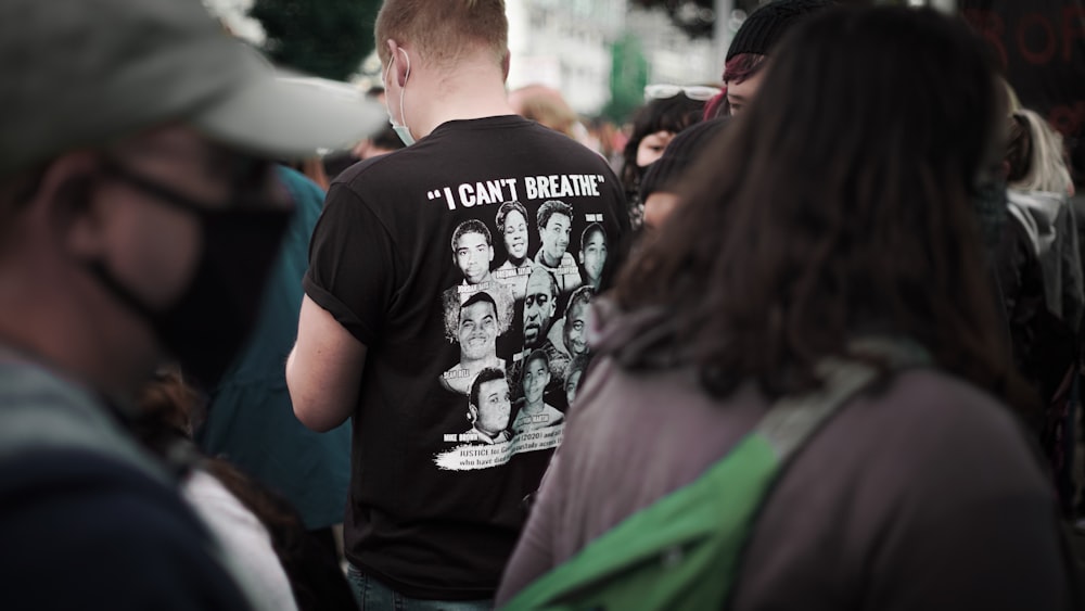 man in black crew neck t-shirt standing beside man in green jacket