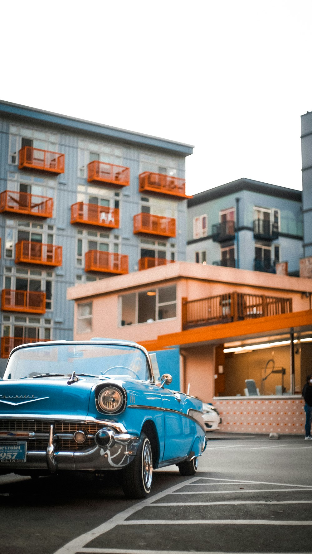 낮 동안 브라운 빌딩 근처에 주차 된 파란색 자동차