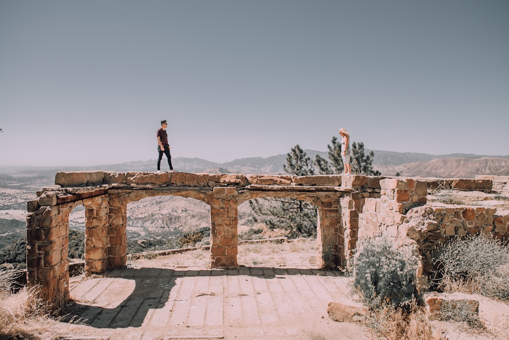 man in black jacket standing on brown concrete bridge during daytime