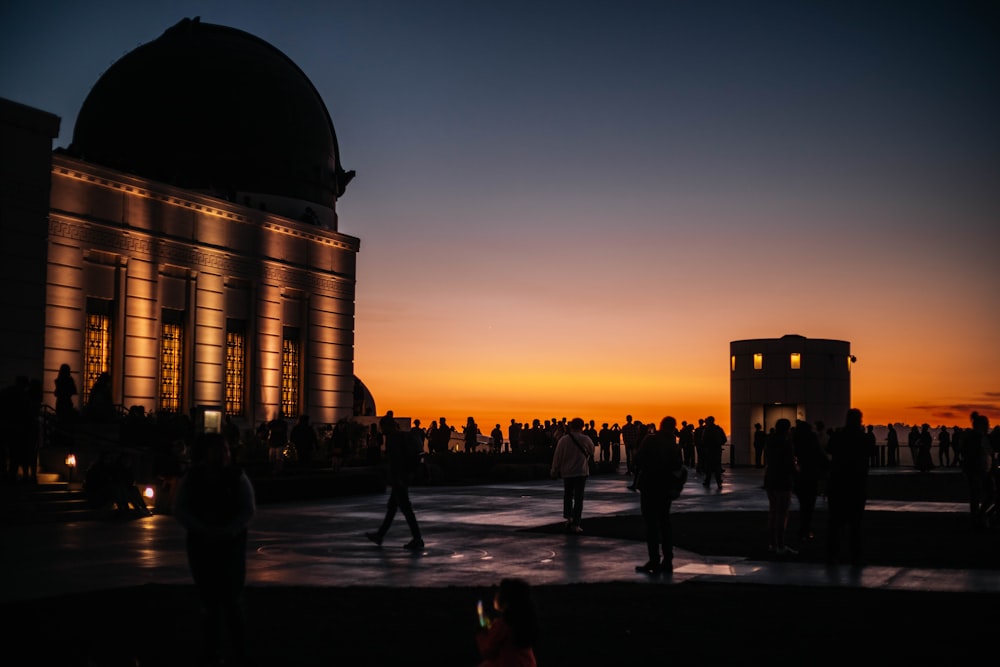 silhouette of people walking on street during sunset