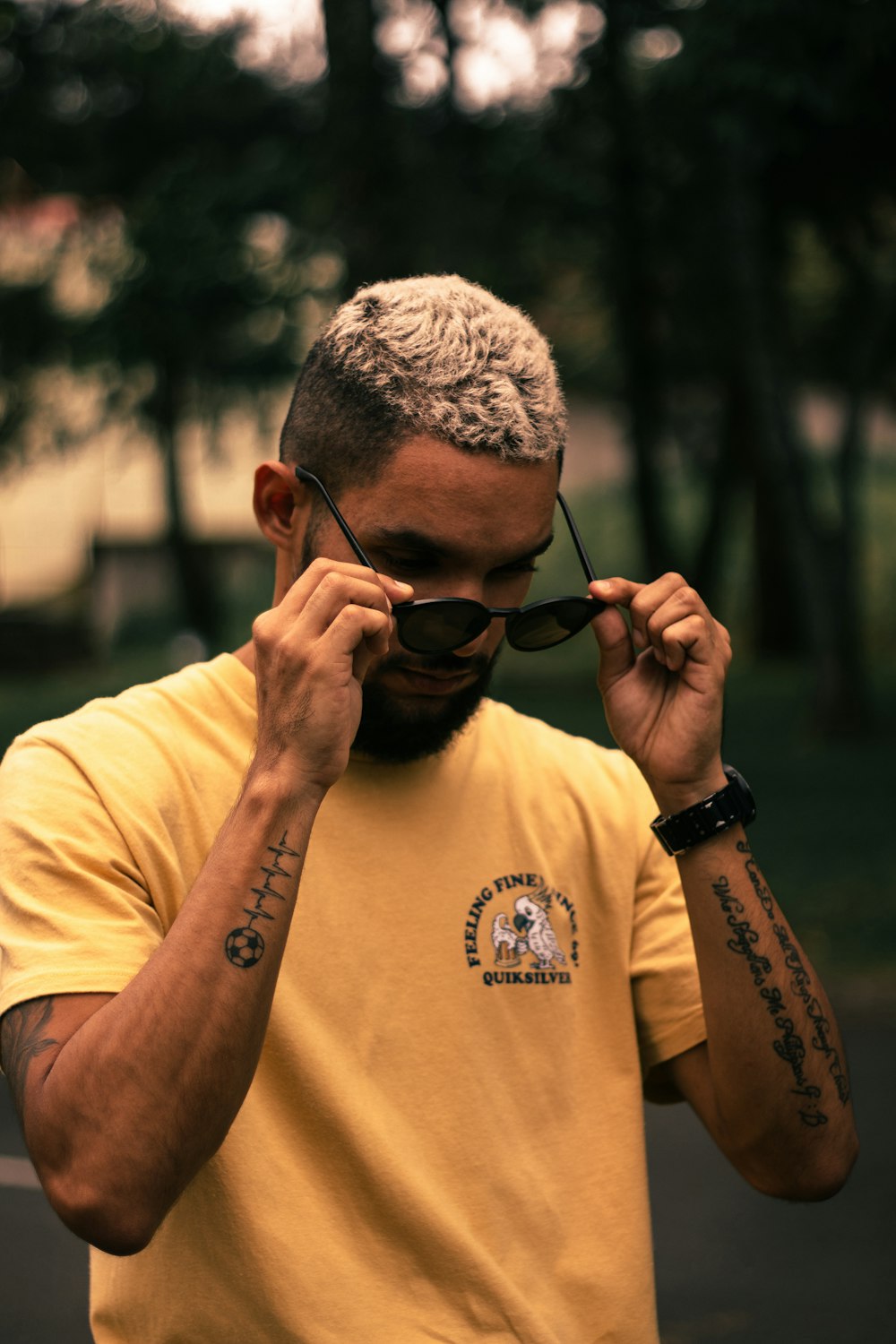 man in yellow crew neck t-shirt wearing black sunglasses