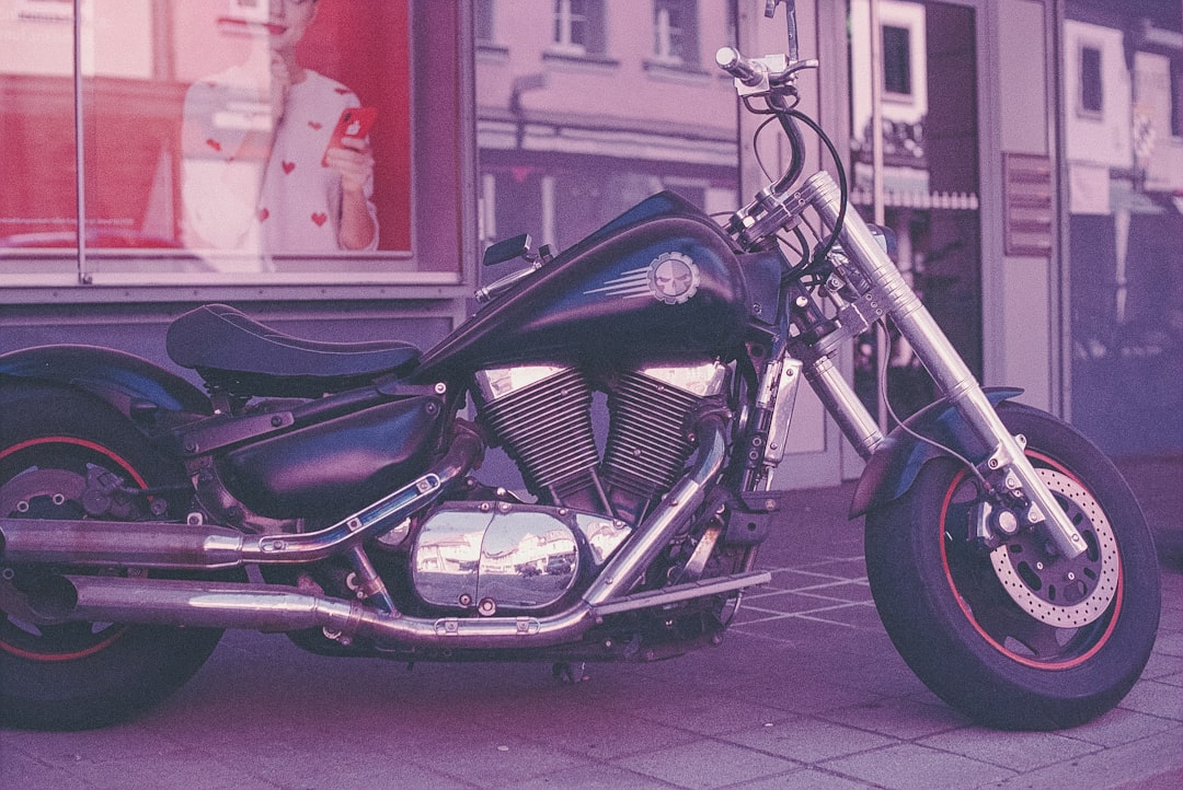 black motorcycle parked beside red wall