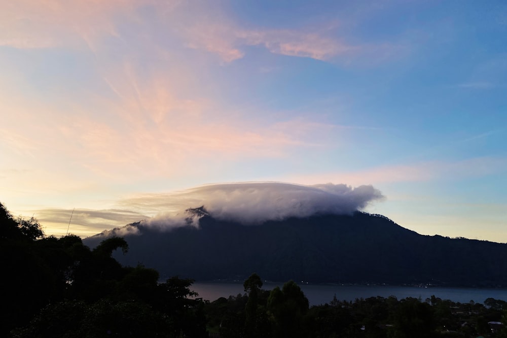 silhouette of mountain under white clouds during daytime