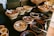 A vibrant display of assorted seeds, dry fruits, and spices arranged neatly on a wooden table.