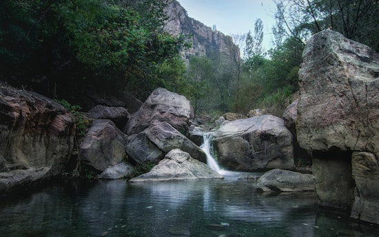 gray rocky mountain beside river during daytime