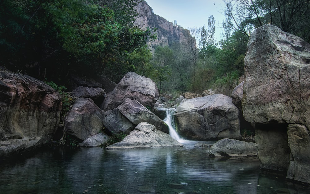 gray rocky mountain beside river during daytime