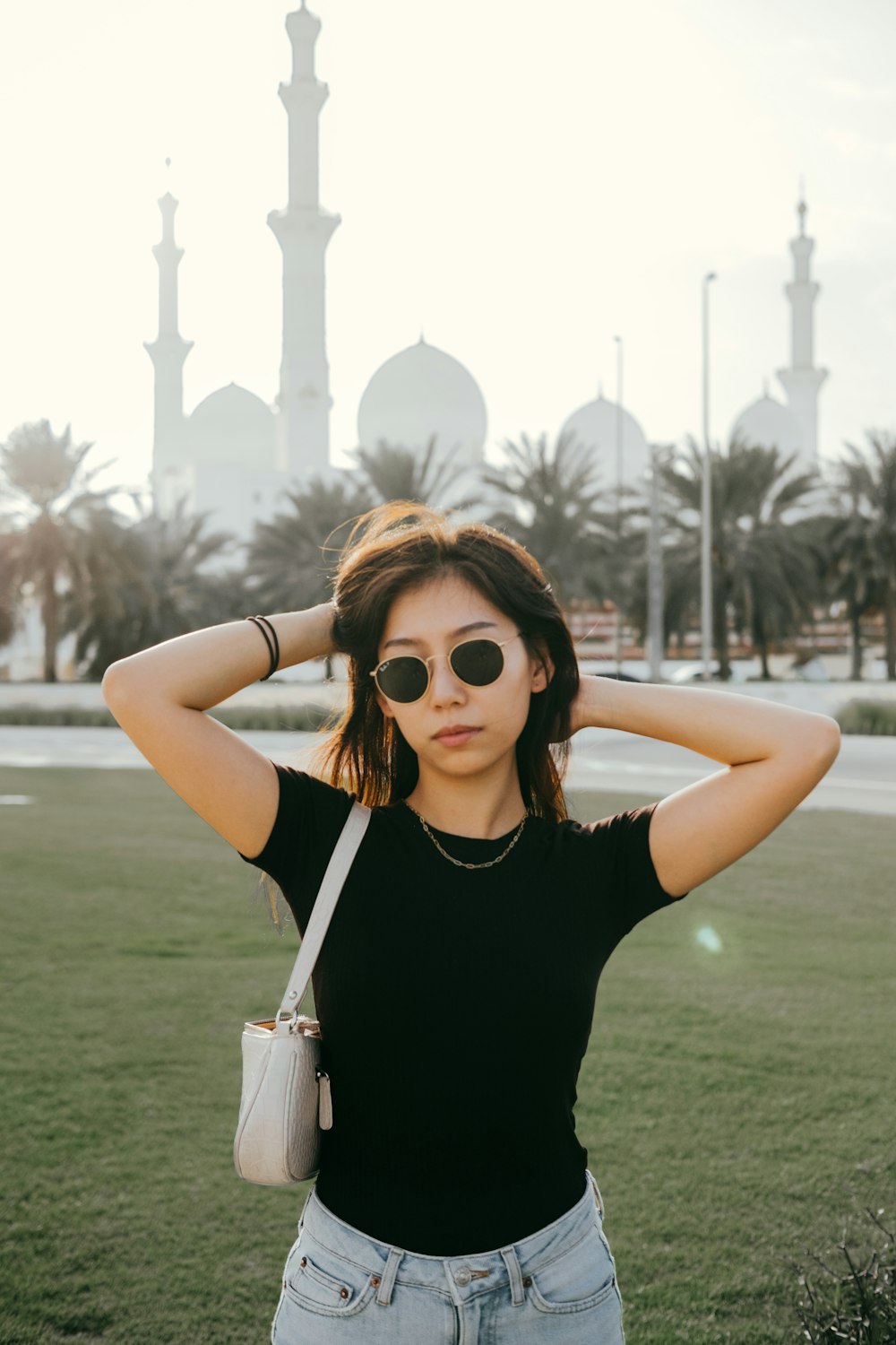 woman in black tank top wearing brown sunglasses holding white disposable cup