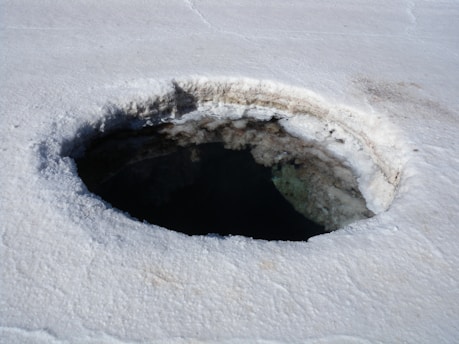 brown and white round hole on white sand