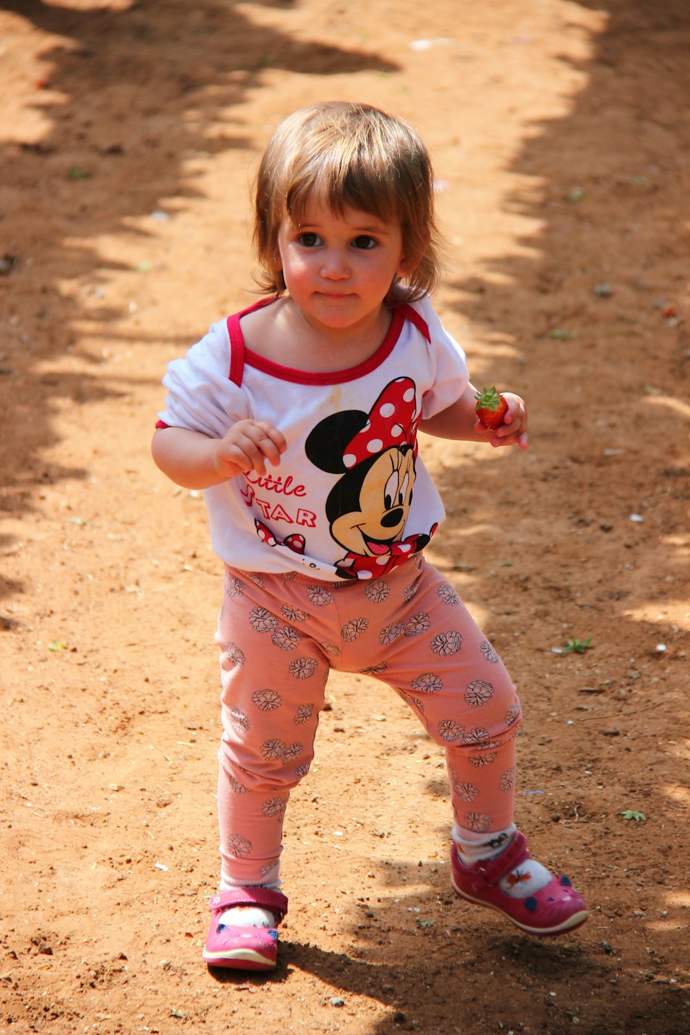 girl in pink and white minnie mouse print onesie