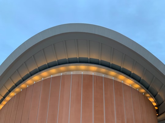 brown wooden round building under blue sky during daytime in House of World Cultures Germany