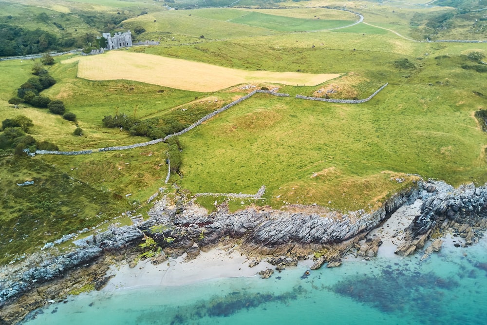 aerial view of green grass field near body of water during daytime