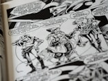 A black and white comic book page features three characters having a conversation. They wear futuristic attire with geometric patterns and accessories. Speech bubbles contain dialogue between the characters, and the background includes stylized designs.