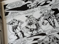 A black and white comic book page features three characters having a conversation. They wear futuristic attire with geometric patterns and accessories. Speech bubbles contain dialogue between the characters, and the background includes stylized designs.