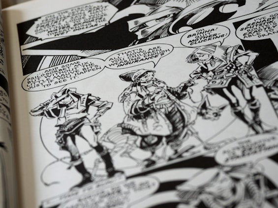A black and white comic book page features three characters having a conversation. They wear futuristic attire with geometric patterns and accessories. Speech bubbles contain dialogue between the characters, and the background includes stylized designs.