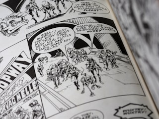 A black and white comic book page featuring a group of armored characters walking together. Speech bubbles contain dialogue, and the background displays some architectural details and signage.