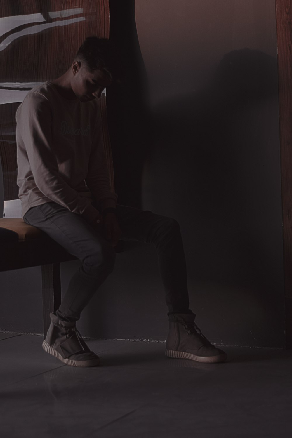 man in white dress shirt and black pants sitting on brown wooden table