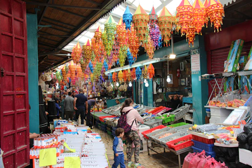 A bustling scene inside Yiwu International Trade Market with buyers and sellers engaging over colorful small commodities.