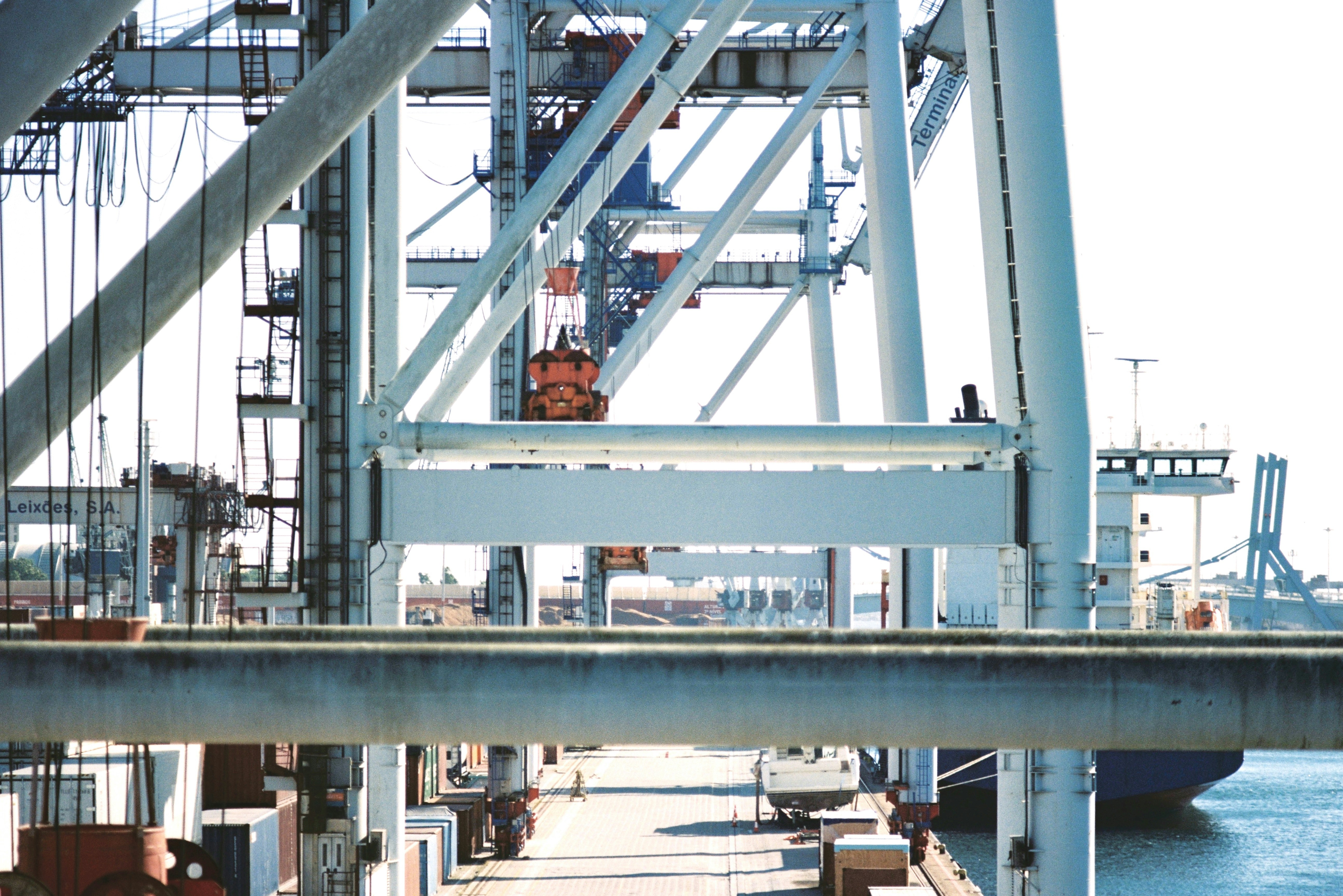Cargo containers at port with cranes in bright daylight, shipping logistics