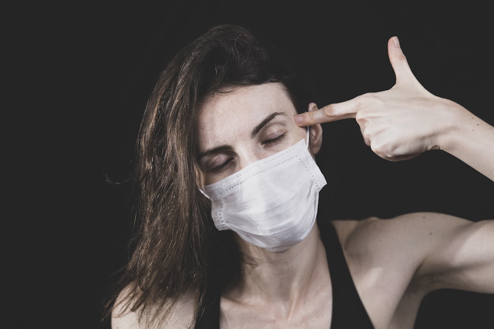 woman in black tank top wearing white face mask