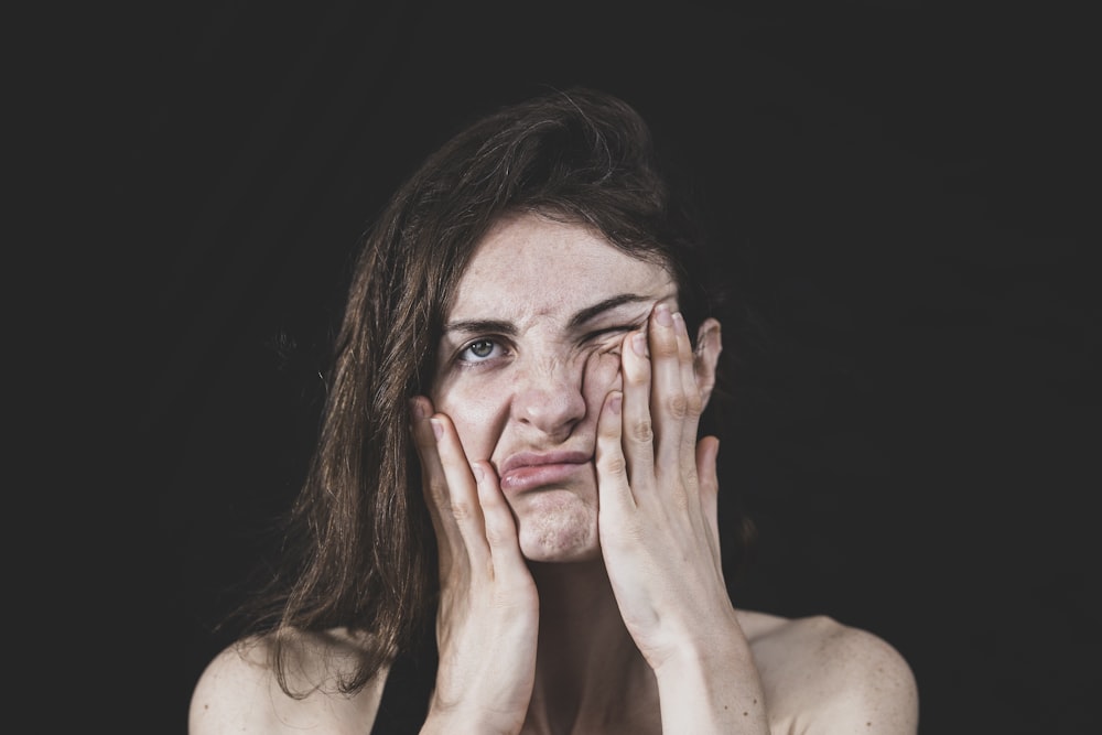 woman covering her face with her hand