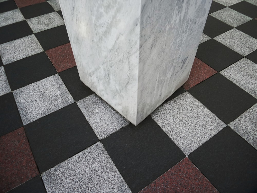 white concrete post on black and white checkered floor
