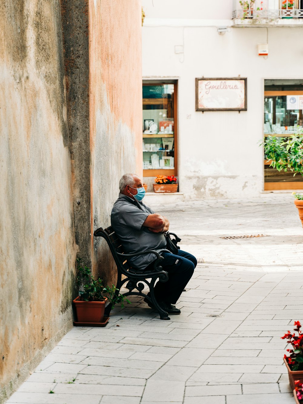 uomo in giacca nera seduto sulla poltrona nera