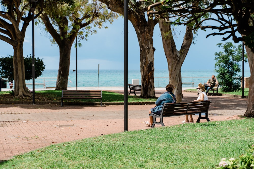 woman in blue dress sitting on brown wooden bench