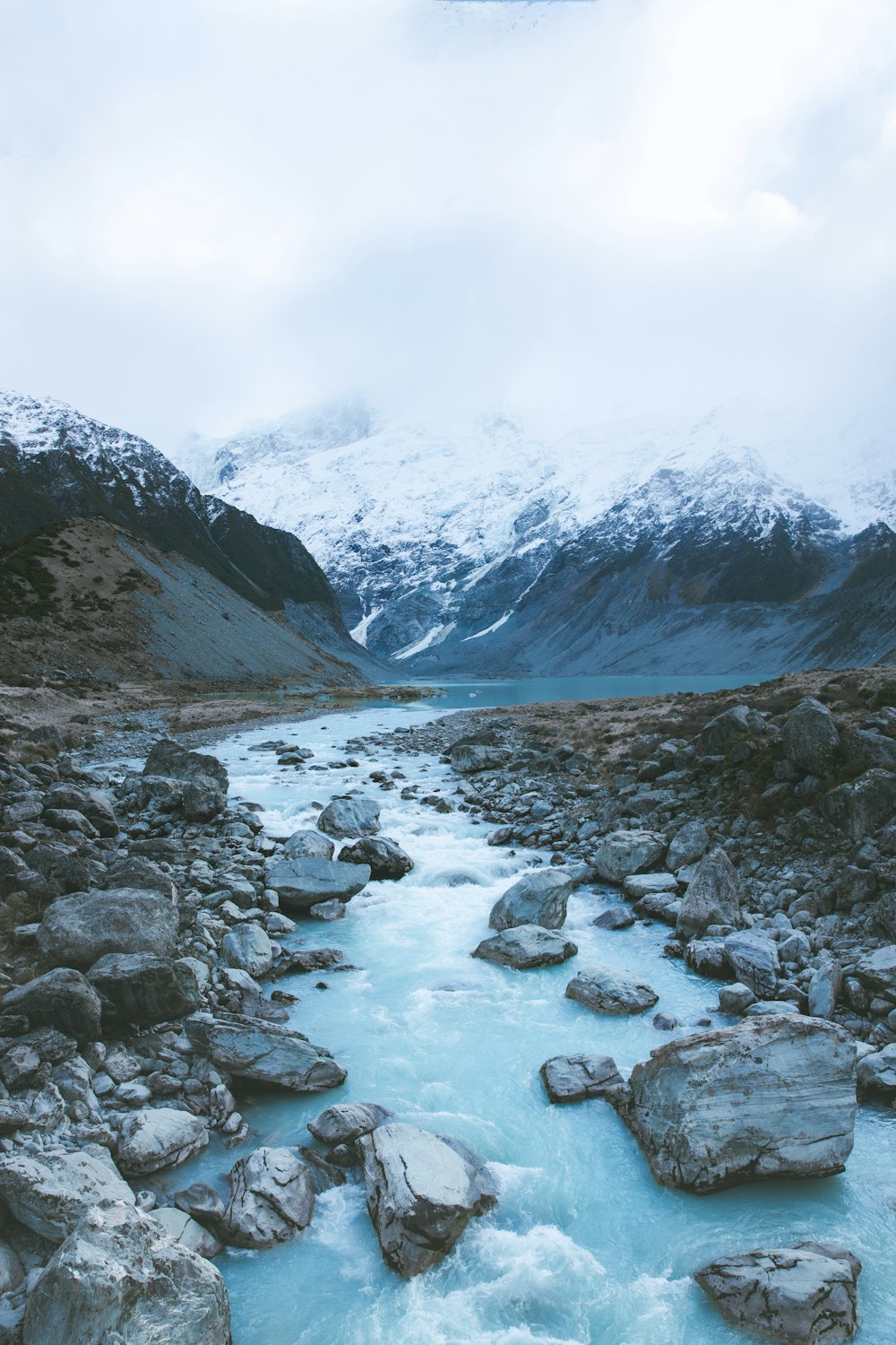 rocky river in between mountains during daytime