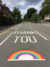 black asphalt road with rainbow sign