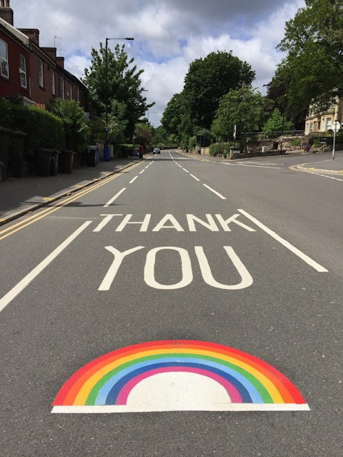 black asphalt road with rainbow sign