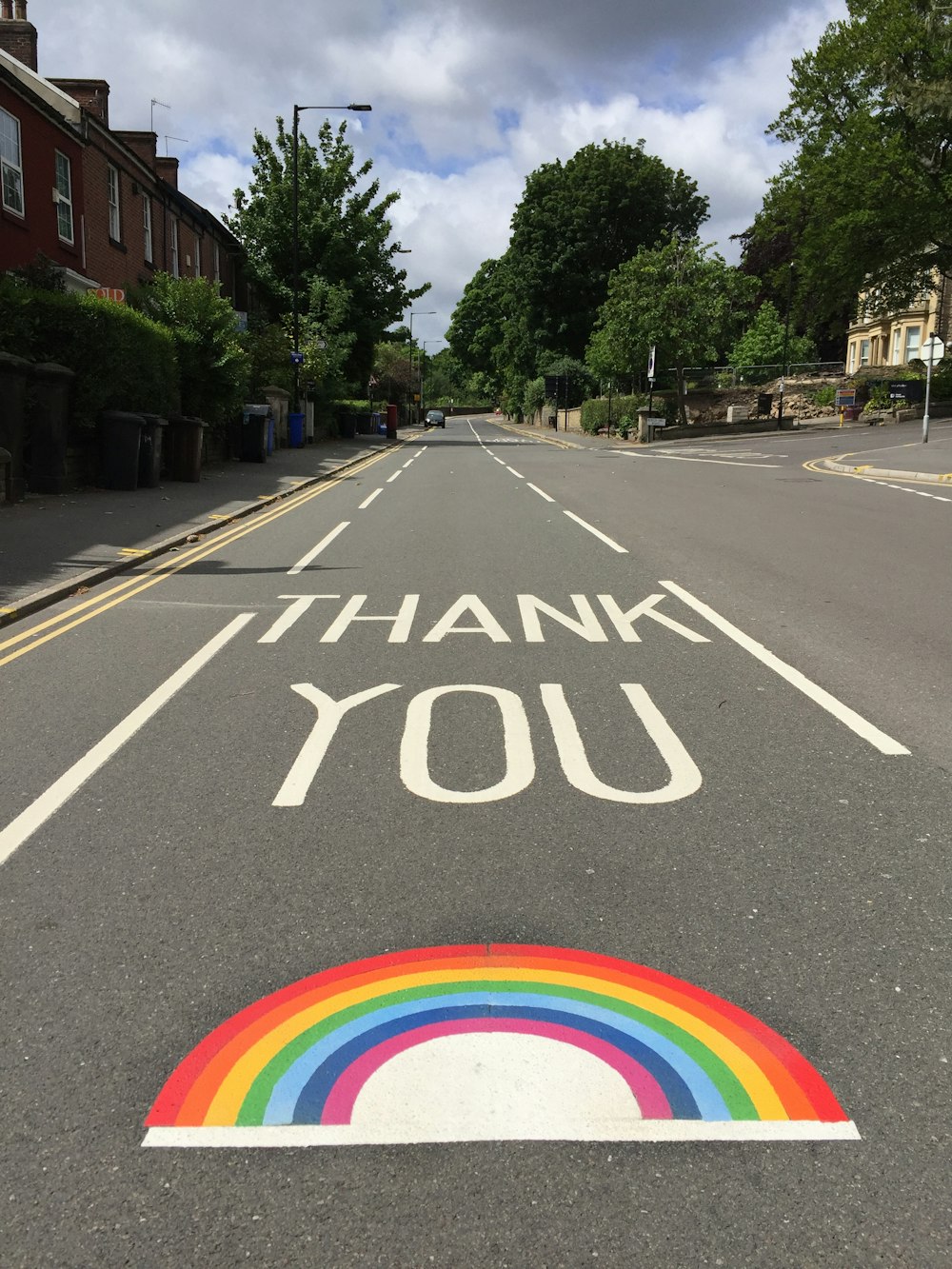 black asphalt road with rainbow sign