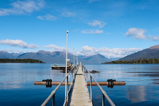brown wooden dock on lake during daytime in Te Anau New Zealand