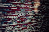 Several lines of source code are displayed on a screen. The code includes text in different colors which likely categorize different types of information such as variables, functions, and comments.