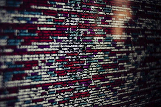 Several lines of source code are displayed on a screen. The code includes text in different colors which likely categorize different types of information such as variables, functions, and comments.