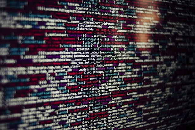 Several lines of source code are displayed on a screen. The code includes text in different colors which likely categorize different types of information such as variables, functions, and comments.