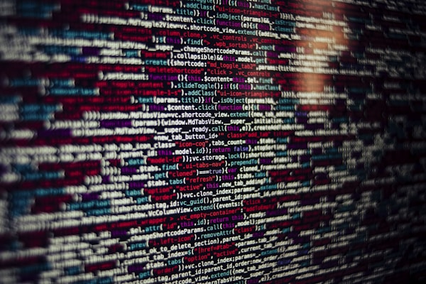 Several lines of source code are displayed on a screen. The code includes text in different colors which likely categorize different types of information such as variables, functions, and comments.