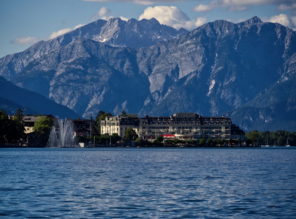 Edificio bianco e marrone vicino allo specchio d'acqua e alla montagna