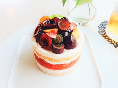 An elegant cake with fruit and cream decoration.