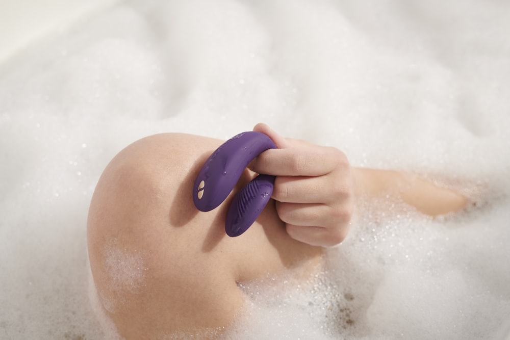 person holding blue plastic hair comb