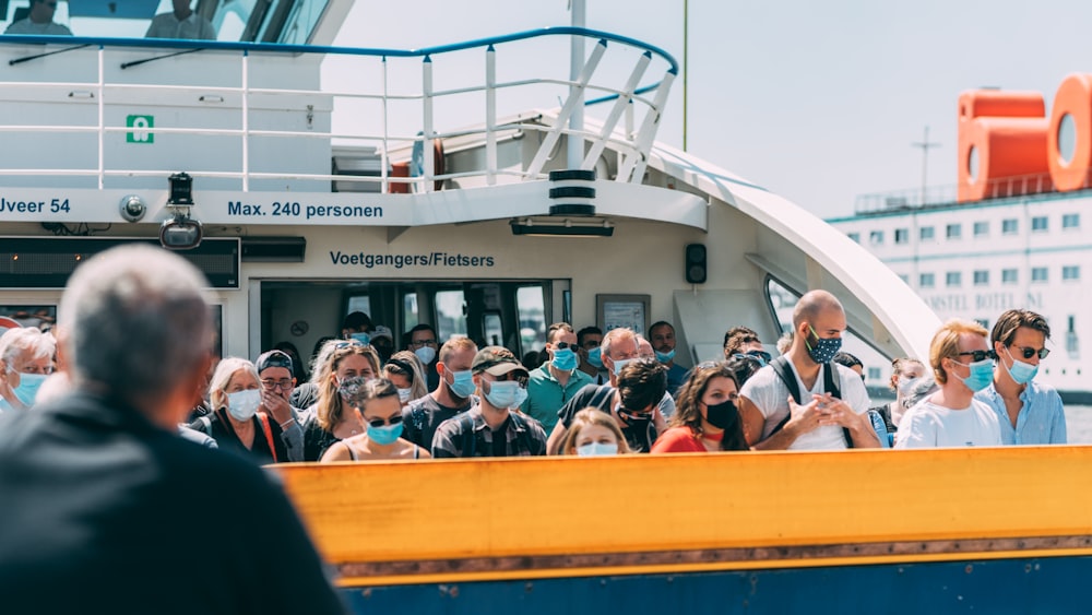 people sitting on yellow and white boat during daytime