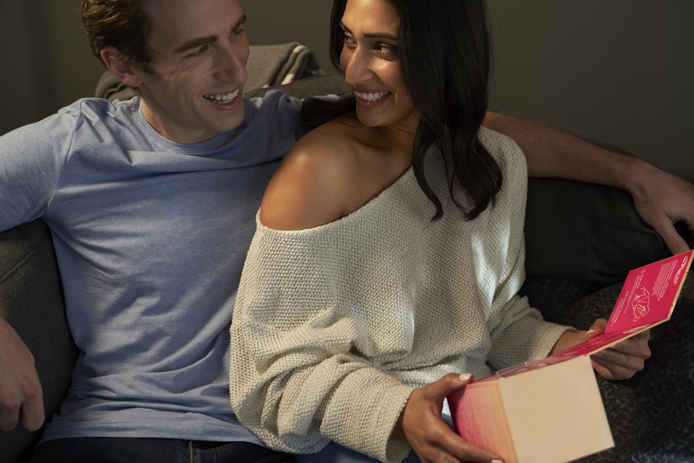 woman in white knit sweater sitting beside man in blue crew neck shirt