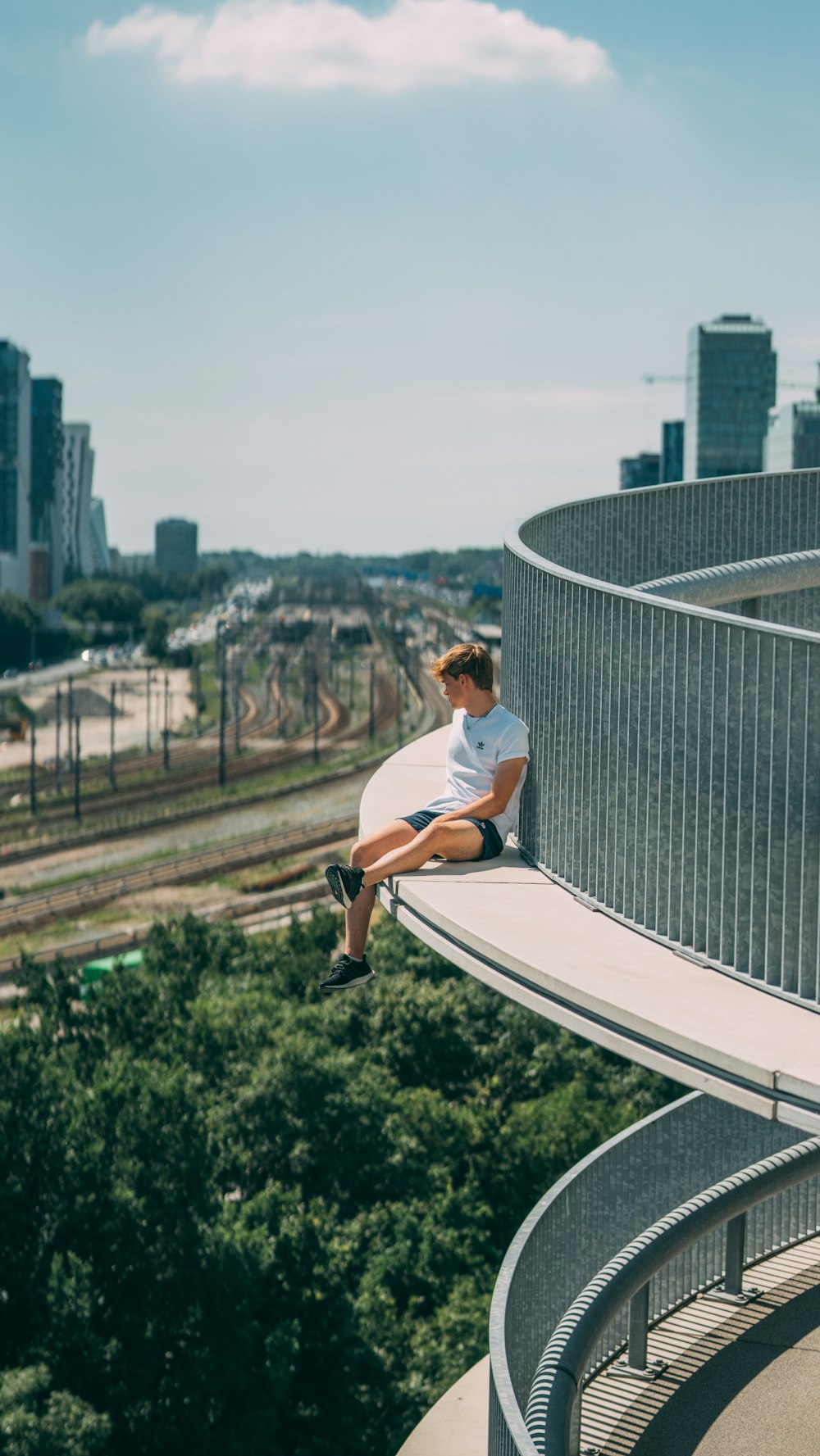 man in white t-shirt sitting on white and black skateboard during daytime